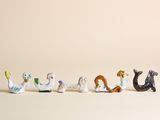 une rangée de petites figurines d'animaux sur une surface blanche