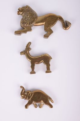 three gold metal animal pins on a white background