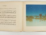 an open book with music notes and a picture of a windmill in the background