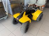 a yellow four wheeler with a black seat in a room