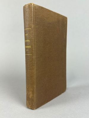 un livre brun posé sur une table blanche
