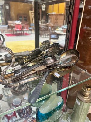 une vitrine contenant de l'argenterie, placée devant une fenêtre