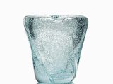 un vase en verre posé sur une surface blanche