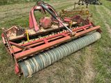 une grosse machine rouge qui est garée dans l'herbe