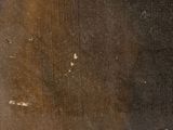 an old book with a black cover sitting on top of a wooden table