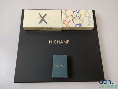 deux boîtes de nishane posées sur une table, à côté d'une boîte d'allumettes
