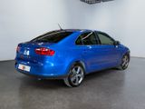 the rear end of a blue car in a white room