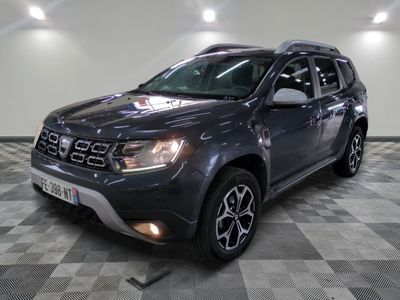 the grey dacia is parked in a room with a checkered floor