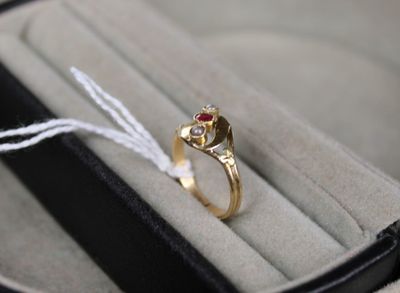 une bague en or sertie d'une pierre rouge, dans un écrin