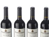 six bottles of wine are lined up in a row on a white surface