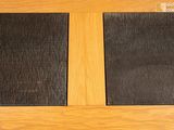 two black placemats on a wooden table