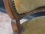 the back of a chair with a brown upholstered seat and wood trim