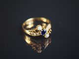 une image montrant un gros plan d'une bague en or posée sur une surface noire