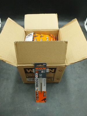 a box of oranges sitting on the floor next to a pair of scissors