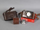 two cameras and a camera case sitting on a table