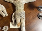 une statue de Jésus posée sur une table en bois, entourée d'autres objets