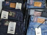 several pairs of men ' s jeans are stacked on top of each other