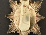 a gold medal with a white stone in the center