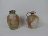 deux vases posés l'un à côté de l'autre sur une surface blanche