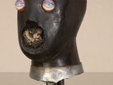 une sculpture représentant une tête d'homme posée sur un socle métallique