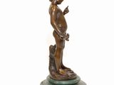 bronze statue of a boy with a dog on a marble base