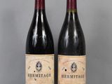 deux bouteilles de vin rouge sont posées l'une à côté de l'autre sur une table