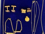 un gros plan sur un plateau bleu sur lequel sont disposés des bijoux en or