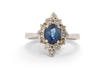 un gros plan d'une bague sertie d'un saphir bleu entouré de diamants