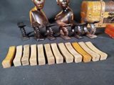 several pieces of carved wood sit on a table next to a suitcase