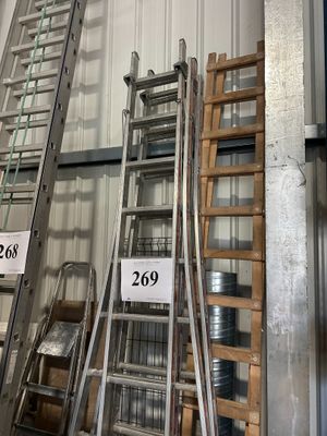 de nombreuses échelles empilées dans un entrepôt
