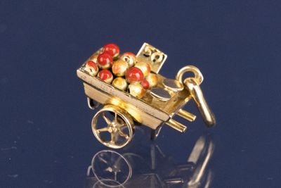 un pendentif plaqué or orné d'un chariot rempli de perles