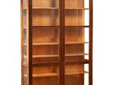 une grande bibliothèque en bois avec des portes vitrées et des étagères