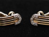 une paire de boucles d'oreilles en or et diamants sur une surface noire