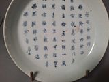 a white plate with blue writing on it on a table