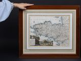 une personne tenant une photo encadrée représentant une carte de l'Europe