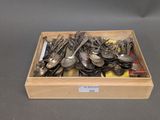 many spoons and spoon knives in a wooden box