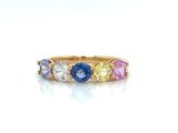 a close up of a gold ring with multi colored stones