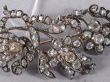 a silver brooch with a bunch of diamonds on it