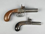 deux vieux revolvers posés côte à côte sur une surface blanche