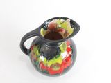un vase noir orné d'un motif rouge et vert