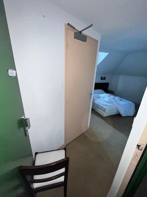 une chaise dans un coin de la pièce, à côté d'un lit