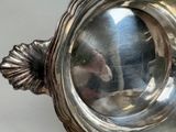 a silver bowl with a mouse in it on a table