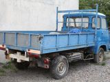 a blue truck parked in front of a white building