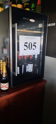 des bouteilles de vin sont posées sur une table devant une cave à vin