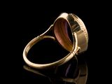 an image of a gold ring with a purple stone in it