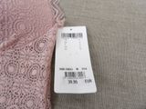 the label on the top of a pink lace bralet is attached to the bottom of the bralet
