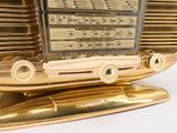 an old fashioned radio sitting on top of a gold stand