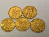 five gold sovereigns of various sizes and shapes