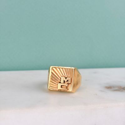 une image représentant une bague-sceau en or ornée d'un motif de rayons de soleil