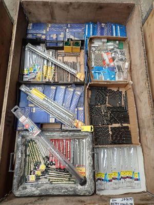 une boîte remplie de vis de toutes sortes et d'autres outils